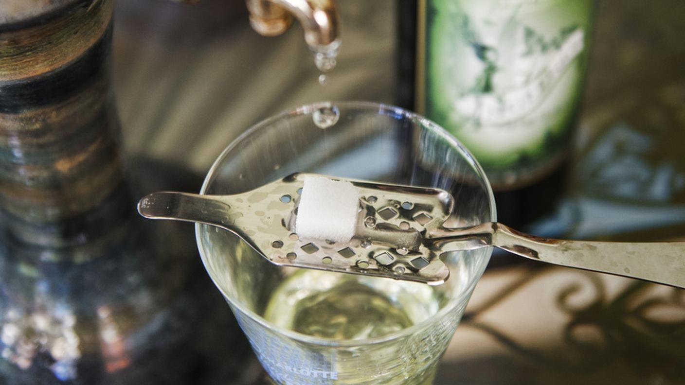 Il distillato gocciola su un cucchiaio da assenzio con una zolletta di zucchero