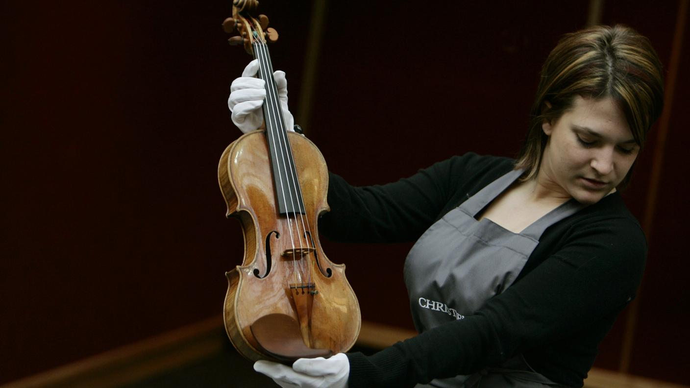 La dipendente di una casa d'aste con il violino noto come “The Hammer”, costruito a Cremona nel 1707 da Antonio Stradivari