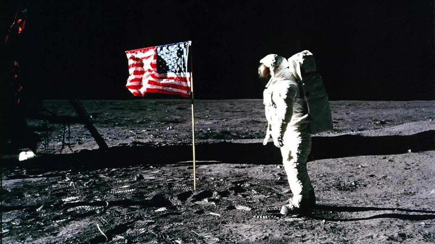 L'astronauta Edwin "Buzz" Aldrin osserva la bandiera americana sulla superficie lunare