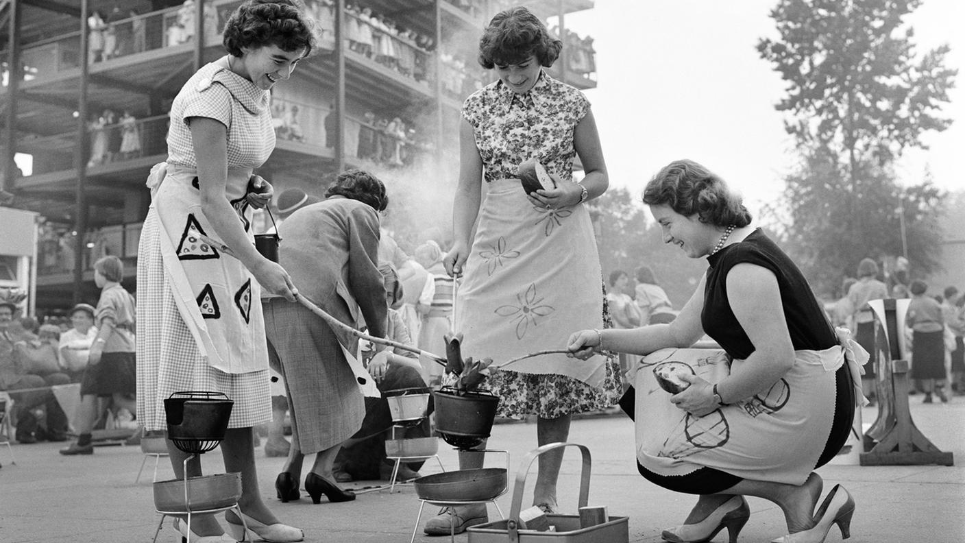 Donne che arrostiscono i cervelas in città 