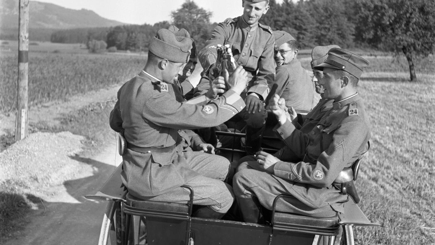 I soldati del corteo nuziale brindano con bottiglie di birra mentre viaggiano in carrozza attraverso la campagna. Foto scattata il 10 settembre 1940 in Svizzera