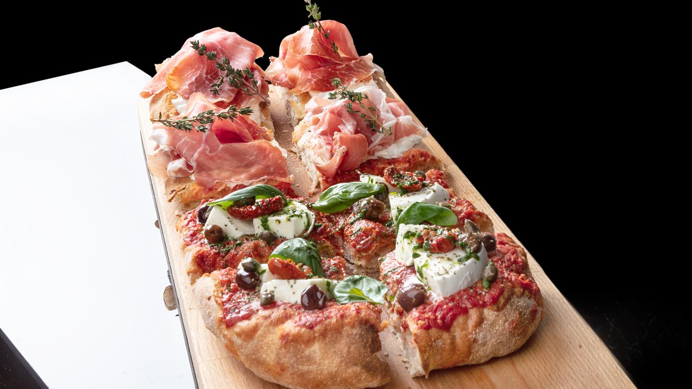 La Pala Rossa e Crudo di Massimiliano Prete: pomodorino di collina del Vesuvio, bufala DOP, datterino confit, capperi di Pantelleria, olive di Taggia, emulsione al basilico, Crudo di Parma 24 mesi DOP Riserva, stracciatella, erbe aromatiche di stagione.