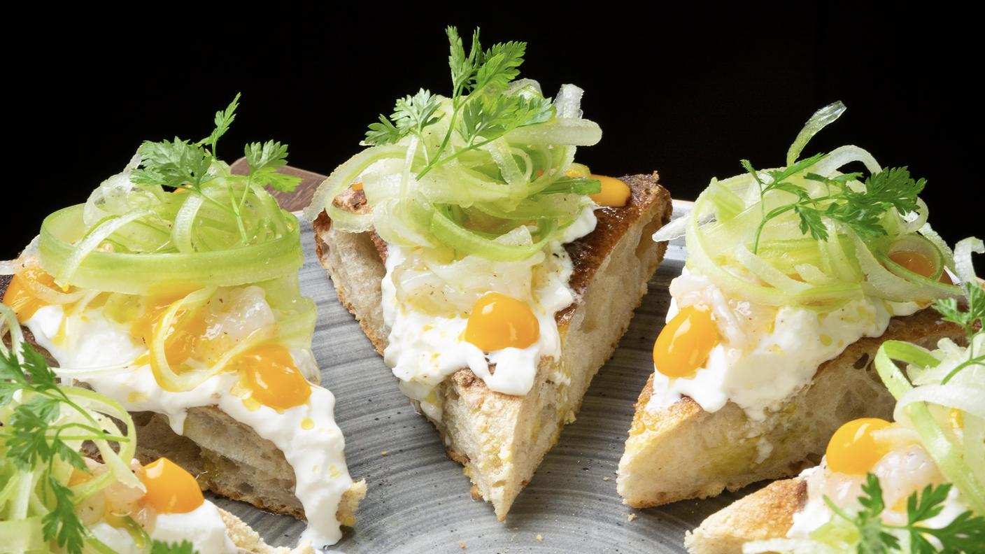 La Scampi a a base croccante con farina di mais e semi di girasole di Massimiliano Prete: scampi, stracciatella, sedano fresco, salsa al mango.