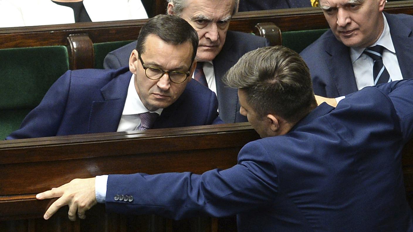 Il primo ministro Mateusz Morawiecki, a sinistra, parla con parlamentare