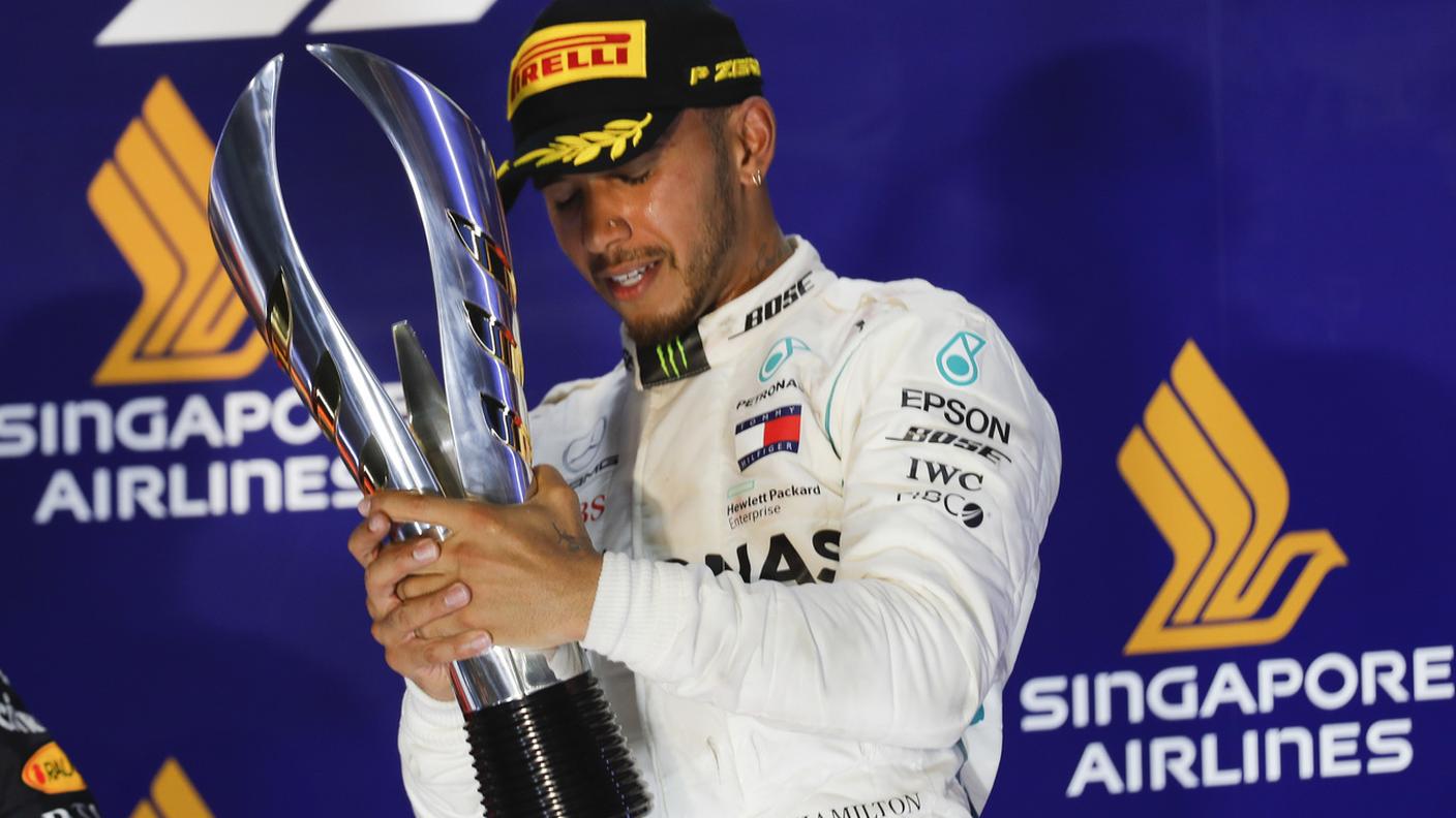 Il pilota della Mercedes con il suo trofeo sul podio 