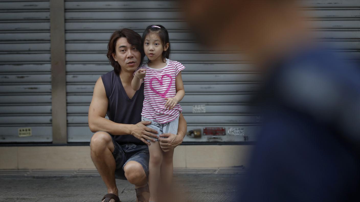 Una bambina assiste alle proteste a Hong Kong