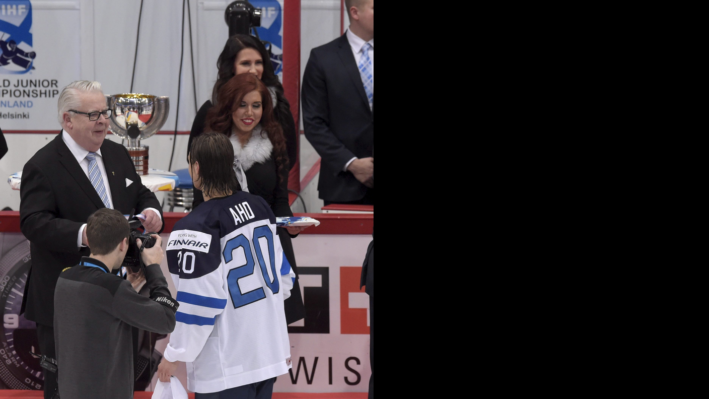 Il vicepresidente dell'IIHF mentre premia il suo connazionale Aho