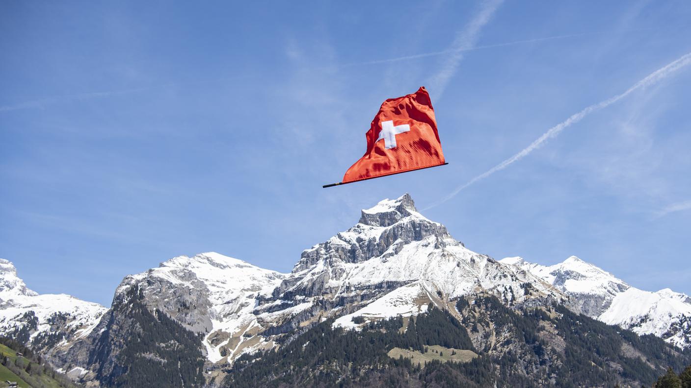 Una bandiera svizzera lanciata da uno sbandieratore a Engelberg