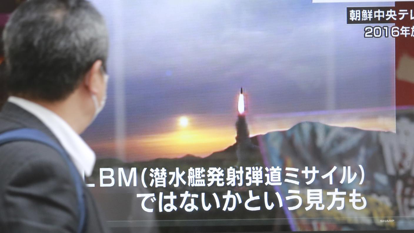 Un giapponese segue gli sviluppi della situazione tramite gli schermi informativi installati a Tokyo 