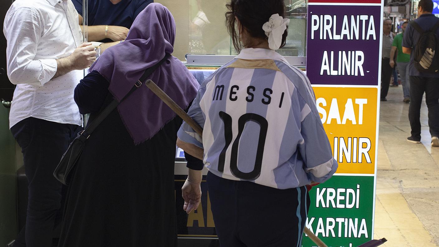 Un'addetta alle pulizie del Gran Bazar di Istanbul lavora indossando la maglia di Lionel Messi. 
