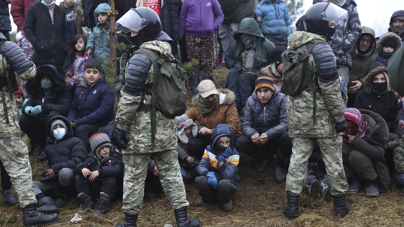Migranti fronteggiati da militari bielorussi 