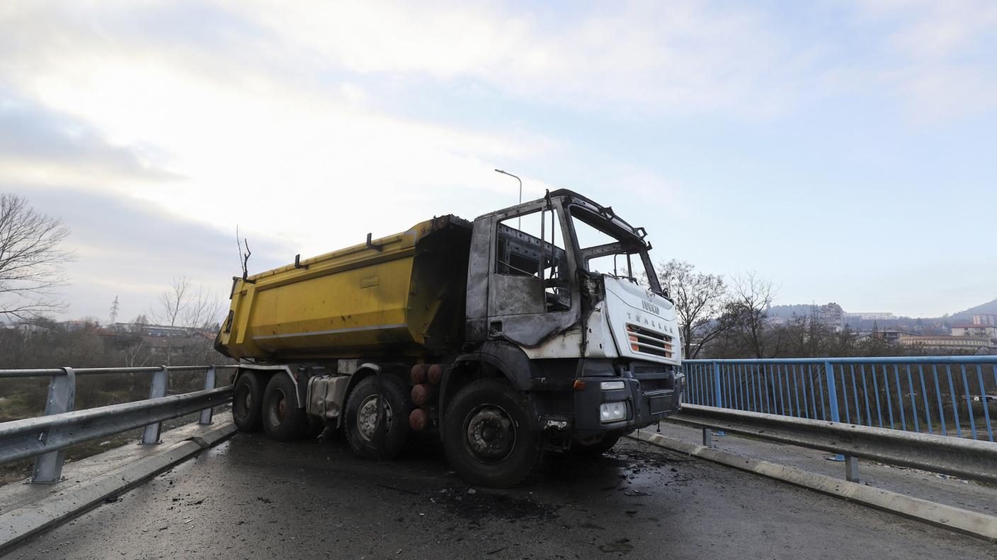 Un camion bruciato messo di traverso a bruciare un ponte