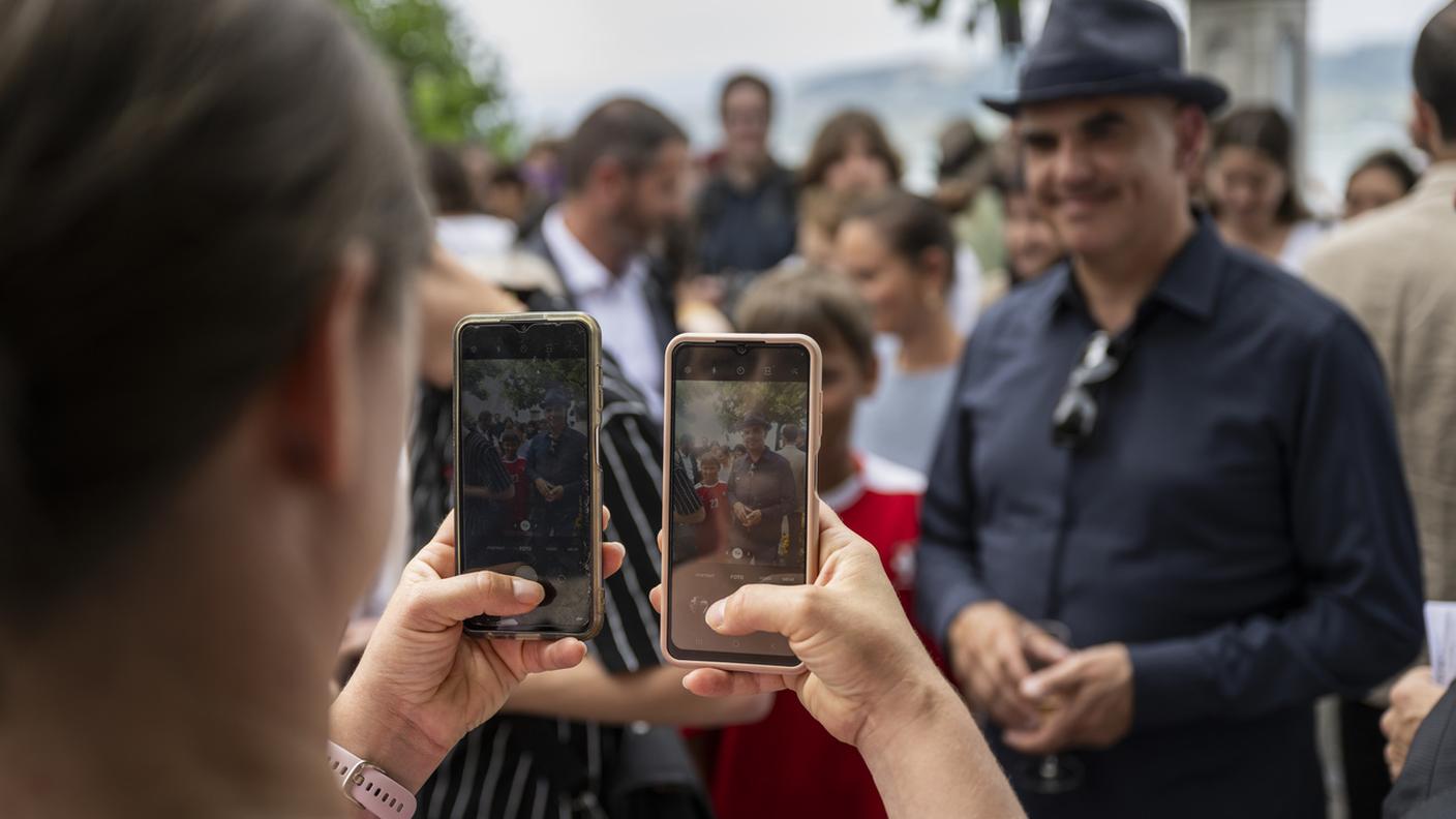 Berset posa per una foto, scattata con due smartphone, all'aperitivo per il pubblico durante il tour del Consiglio federale, a Morat