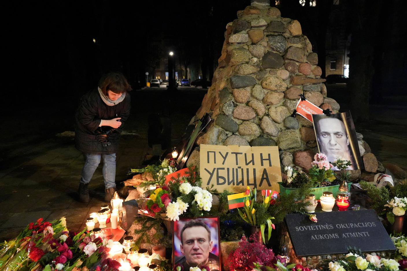 Una donna accende una candela in memoria di Alexei Navalny a Vilnius in Lituania