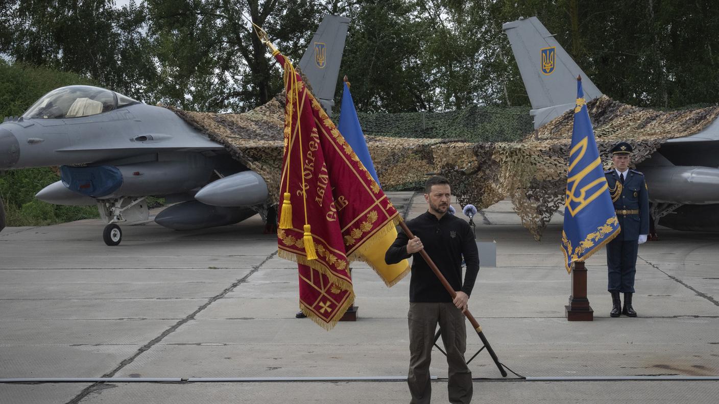 Il presidente ucraino Volodymyr Zelensky davanti a due intercettori F-16