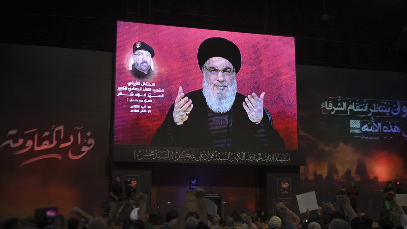 Nasrallah in diretta su uno schermo durante una cerimonia per commemorare la morte del comandante supremo Fouad Shukur, ucciso da un attacco aereo israeliano la scorsa settimana, a Beirut