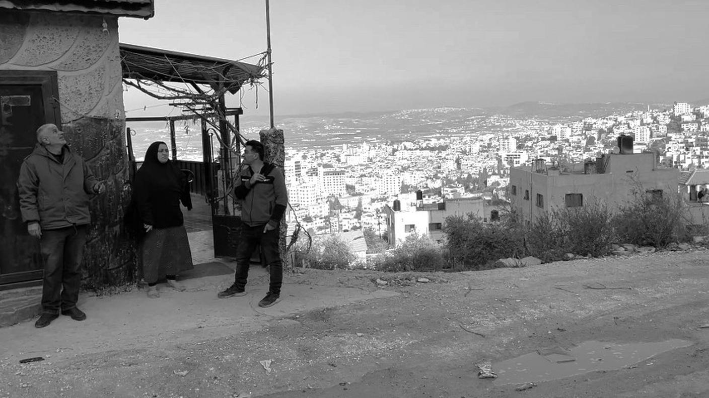 FOTO 12 - Una famiglia del campo profughi di Jenin che guarda verso l'alto mentre sopra volteggiano due droni israeliani (Emiliano Bos - RSI).jpg