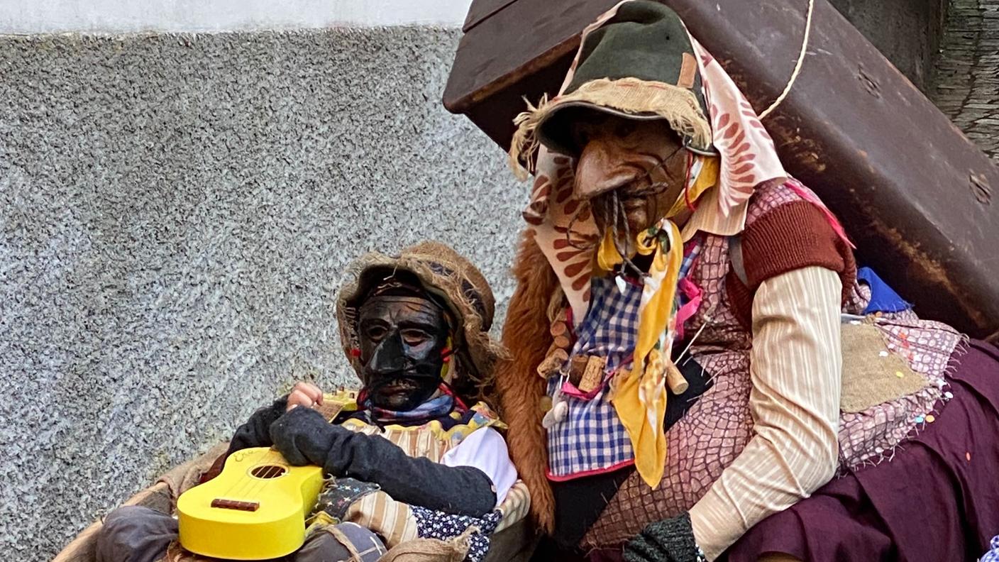 Due costumi del Carnevale di Schignano, con le tipiche maschere in legno