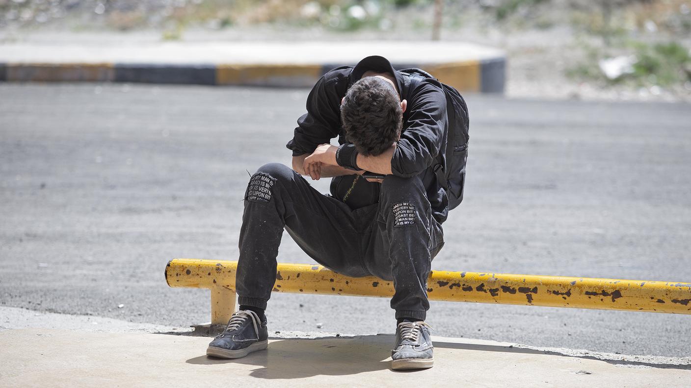 Un ragazzo iraniano che viaggia da solo sembra preso da un momento di sconforto.