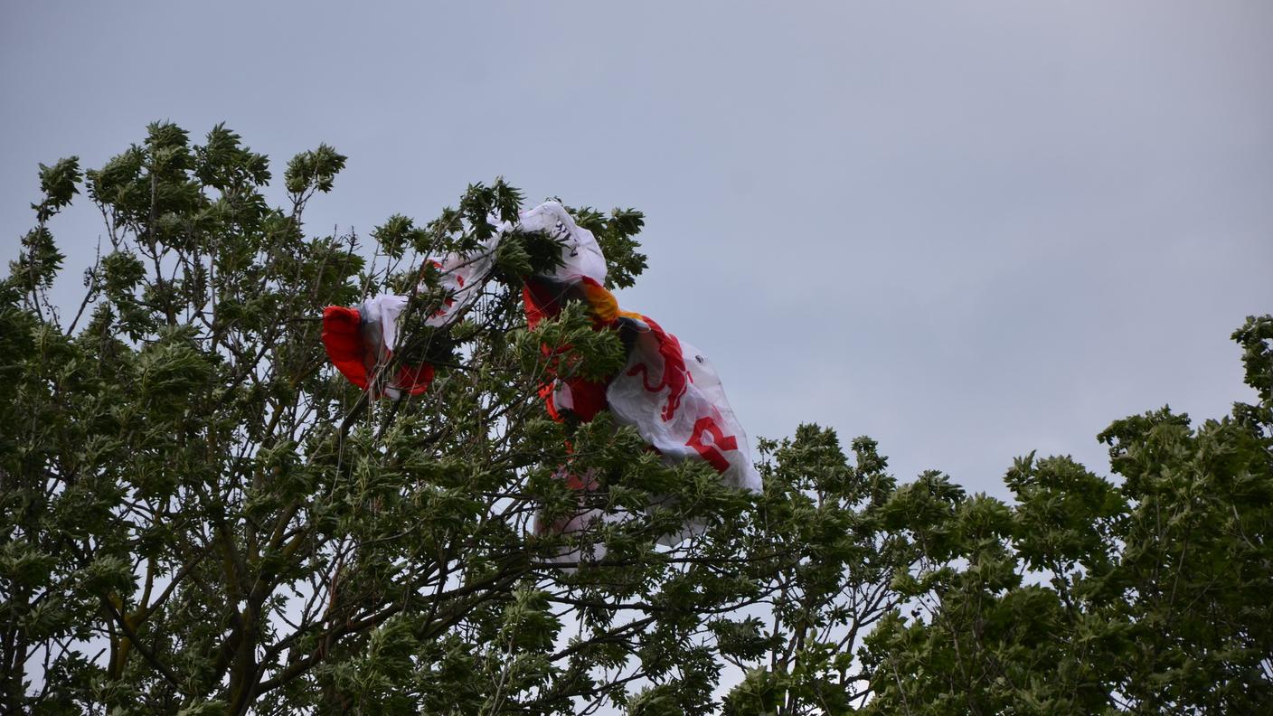 La tela del parapendista si è incastrata tra i rami di un albero