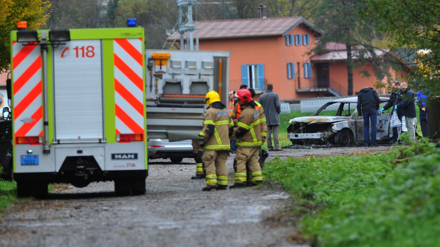 Pompieri e polizia vicini alla vettura carbonizzata