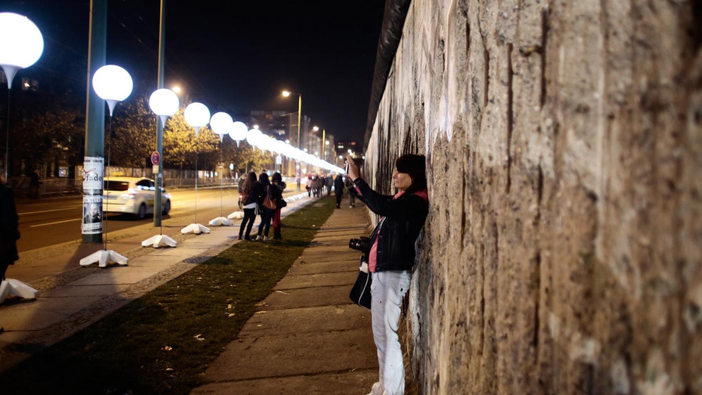 Una donna scatta una foto ai palloni luminosi di Berlino.jpg