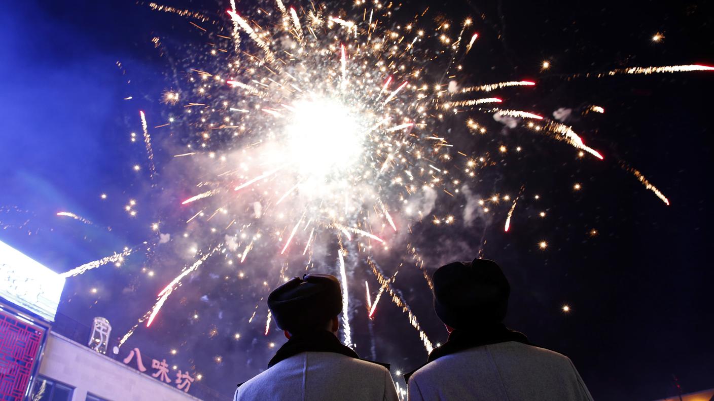 Due agenti di polizia a Pechino ammirano i fuochi d'artificio per il capodanno cinese