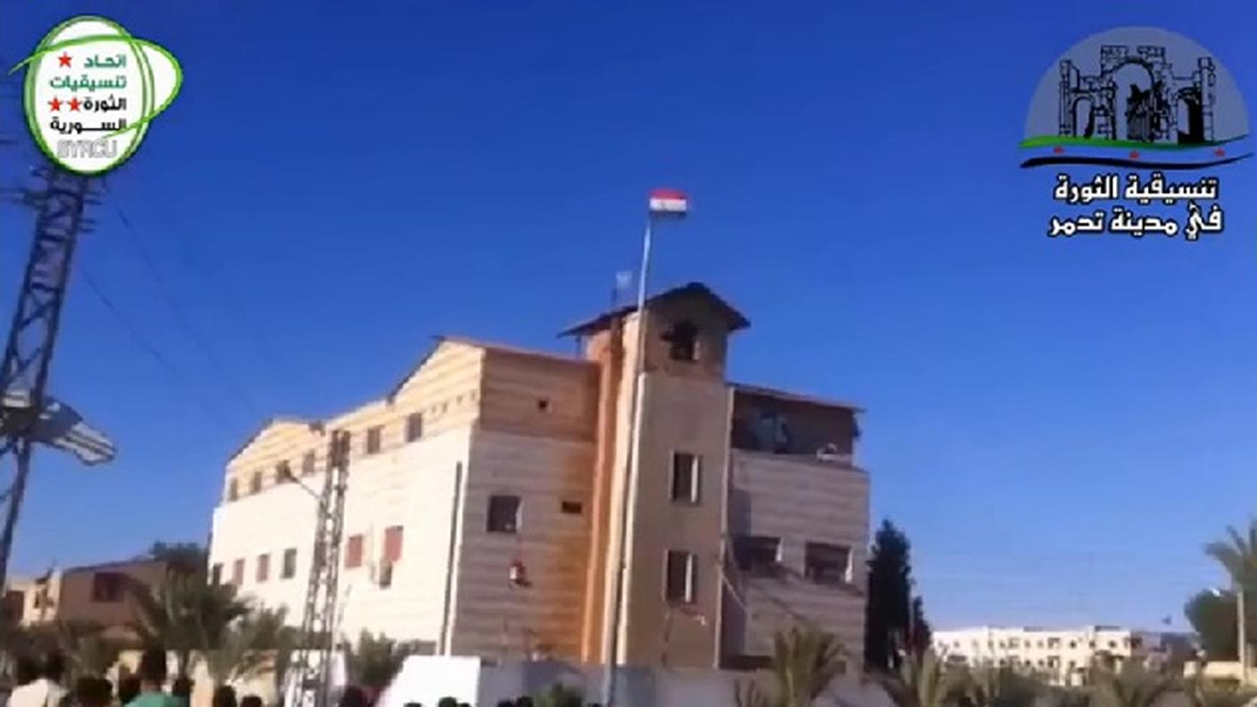 Il vessillo dell'IS esposto alla finestra dell'edificio a Palmira