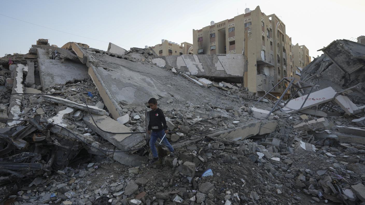 Un bambino palestinese che cammina tra le macerie degli edifici distrutti in un quartiere di Khan Younis, nella Striscia di Gaza