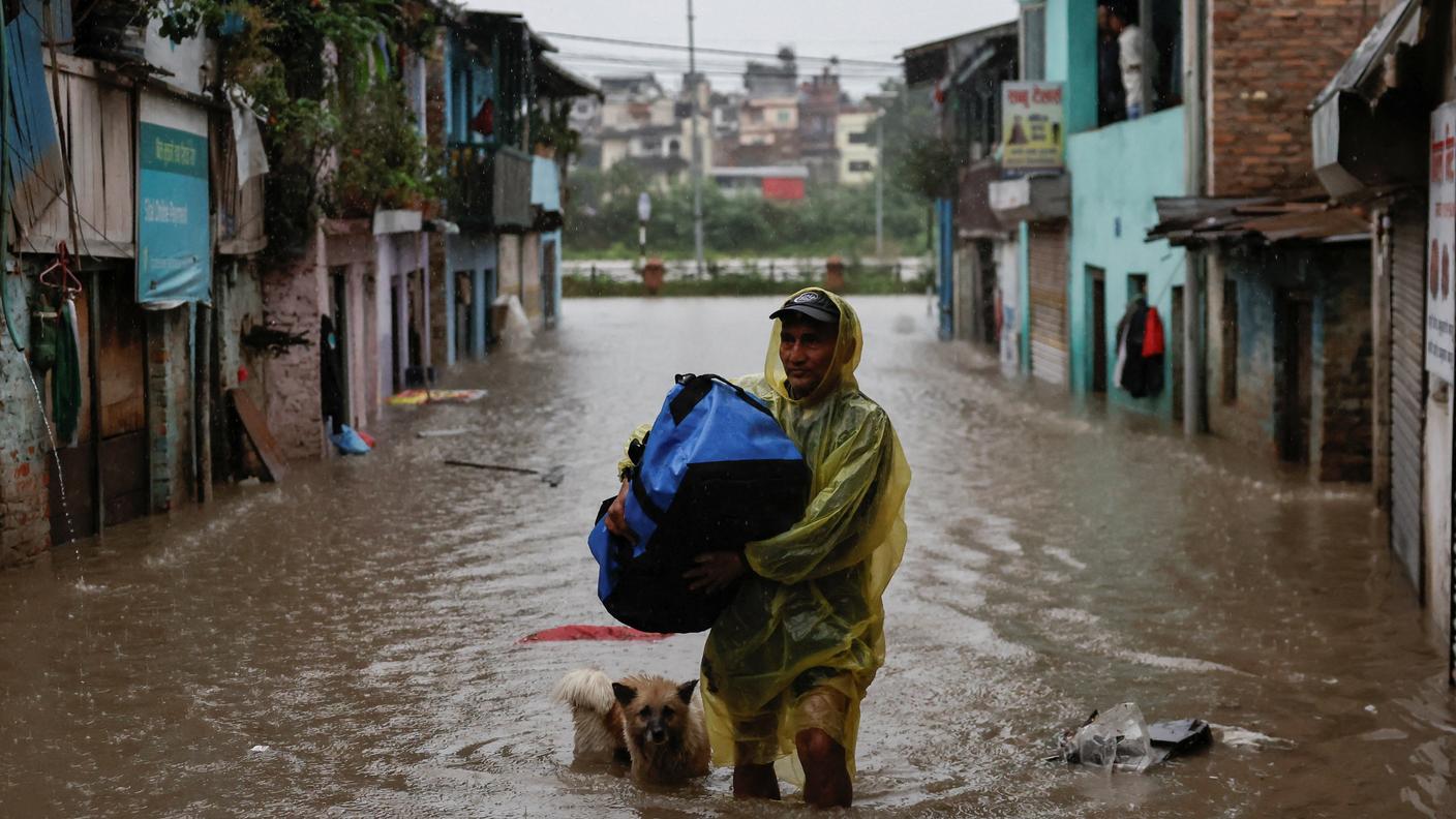 Un uomo tra le strade allagate di Kathmandu, in Nepal