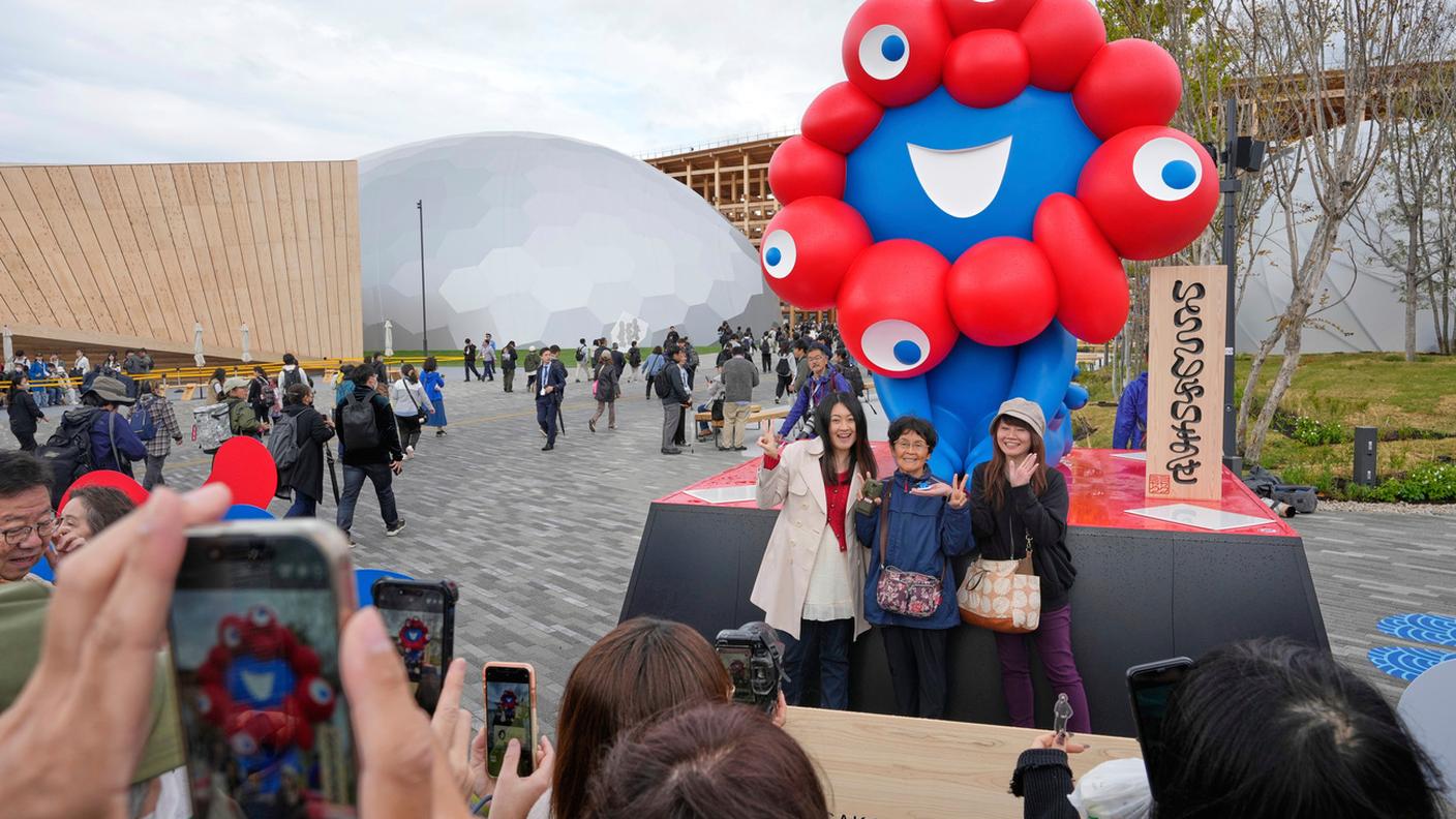 Anche con il cattivo tempo non si rinuncia alla foto con la mascotte dell'Expo Myaku-Myaku