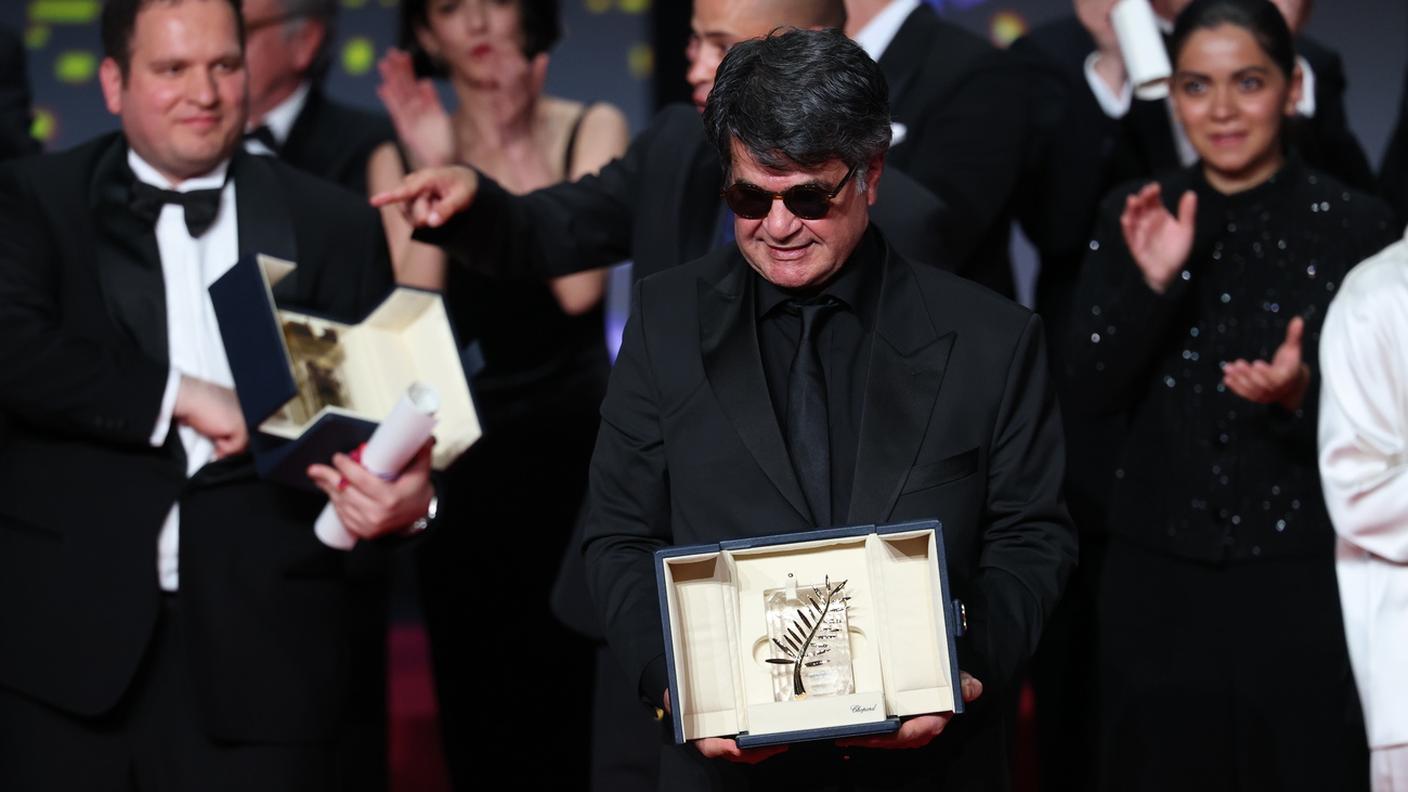 Il regista iraniano Jafar Panahi festeggia sul palco dopo la vittoria