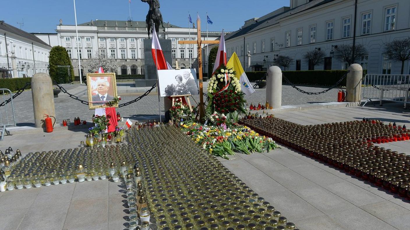 Corone di fiori, lumini e bandiere davanti al palazzo presidenziale a Varsavia