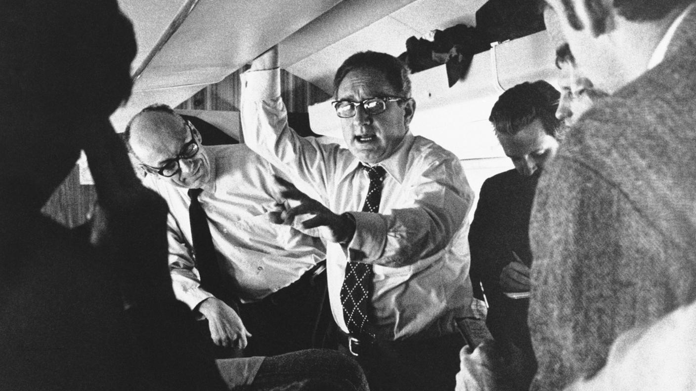 Kissinger, il suo staff e i giornalisti al seguito in volo, nel 1973, in vista di una riunione dei ministri degli esteri della NATO: instancabile "globetrotter" della diplomazia, Kissinger si spostò con assiduità da un Paese all'altro, segnatamente in situazioni di crisi