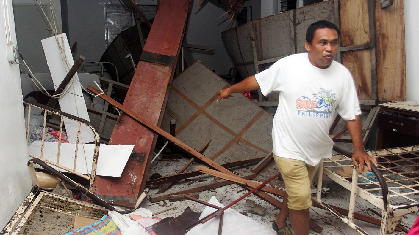 Un uomo verifica i danni causati dal sisma all'ospedale locale di Surigao