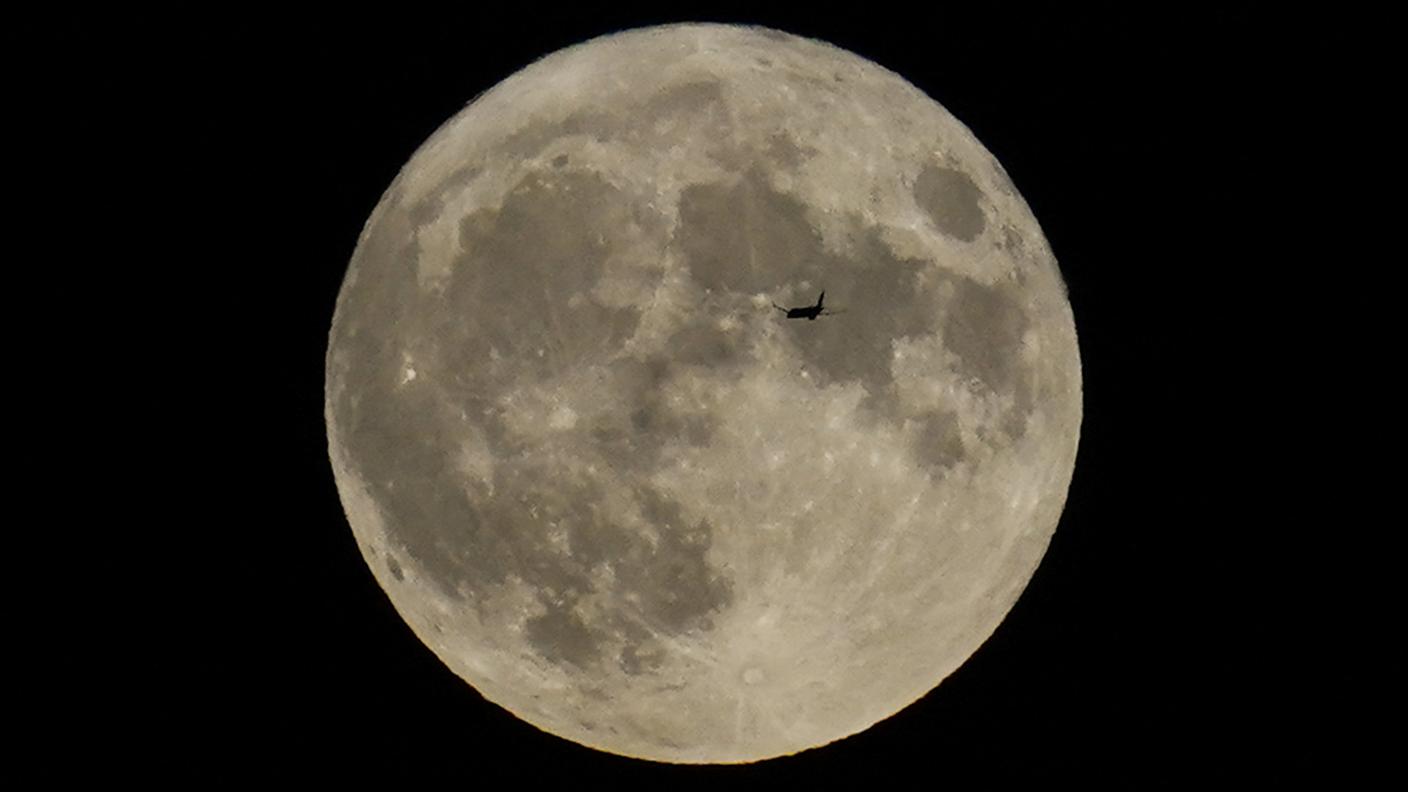 Un aereo vola di fronte alla "super Luna blu" giovedì notte nei cieli di Chicago