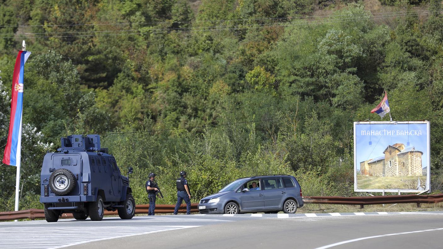Poliziotti kosovari perlustrano vicino a dove uomini armati hanno ucciso un agente domenica