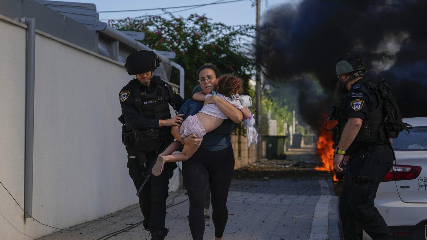 Poliziotti israeliani in soccorso di una donna e una bambina in fuga dai bombardamenti ad Ashkelon
