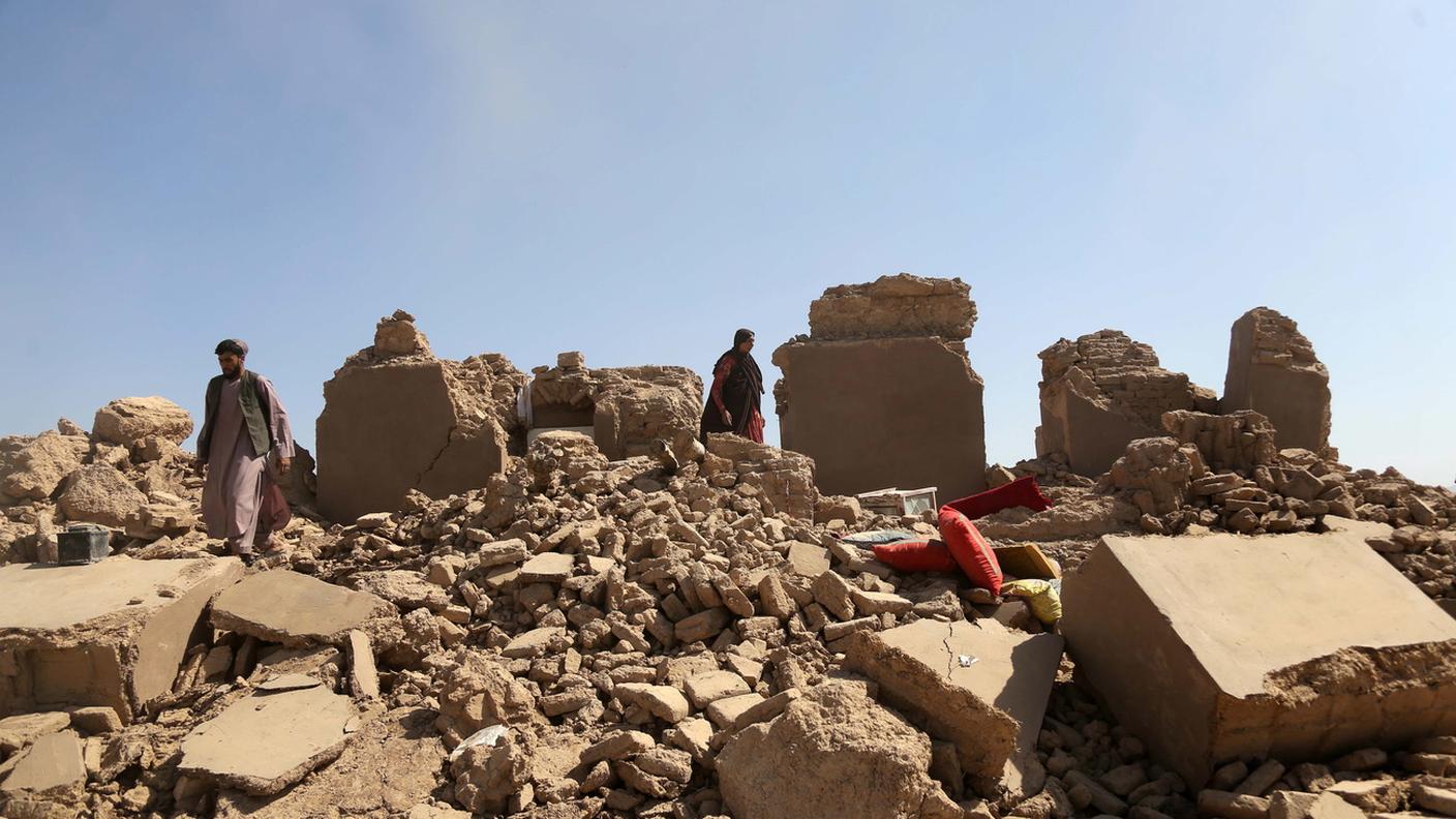 Alcune persone si aggirano tra le rovine di un villaggio devastato dal sisma in Afghanistan