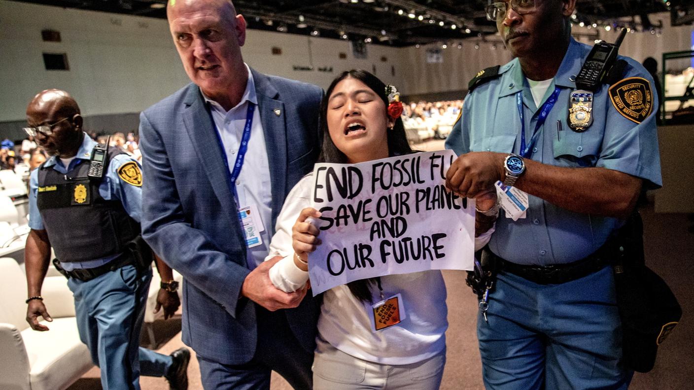 Agenti di sicurezza scortano l'attivista indiana per il clima Licypriya Kangujam durante la Conferenza a Dubai