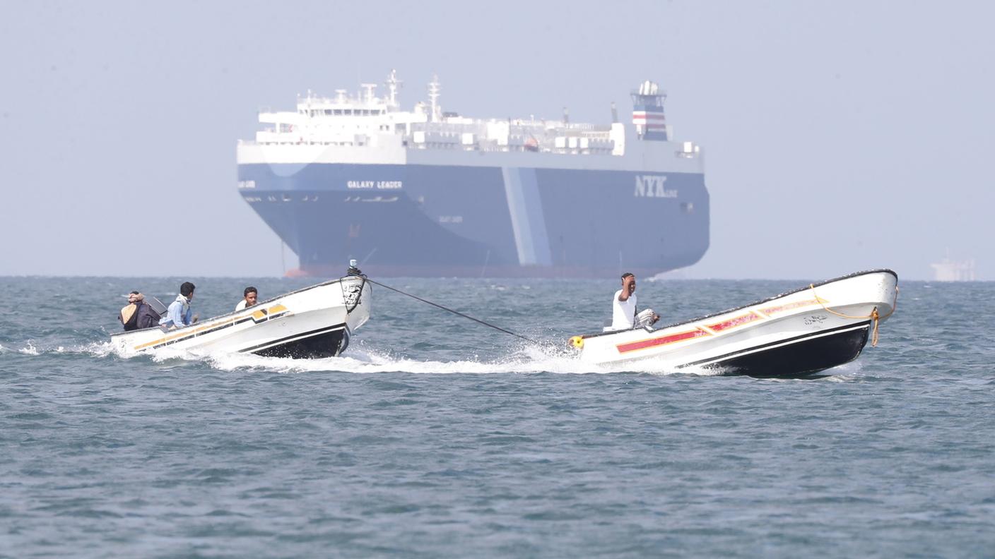 Alcune barche navigano davanti al cargo Galaxy Leader, sequestrato dagli Houthi al largo del porto di Al-Salif, sul Mar Rosso, nella provincia di Hodeidah, Yemen, il 5 dicembre 2023