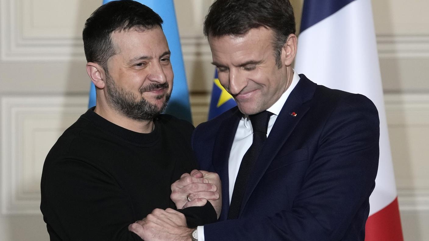 La calorosa stretta di mano fra Zelensky e Macron, durante la conferenza stampa a Parigi con cui è stato presentato l'accordo di sicurezza