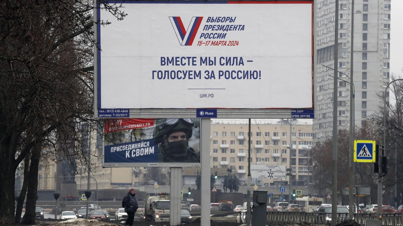 Cartellone per le presidenziali in Russia e dietro uno per il reclutamento di soldati a San Pietroburgo