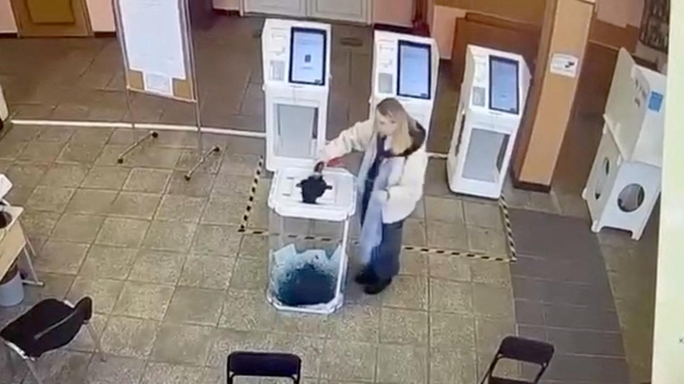 Una donna ripresa mentre versa inchiostro nell'urna