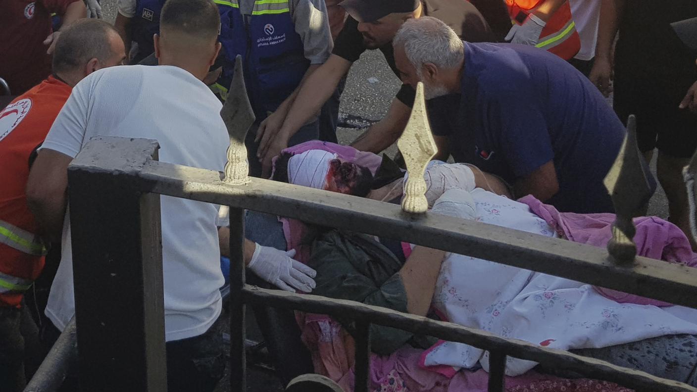 Soccorritori assistono un uomo rimasto ferito dall'esplosione del suo cercapersone al porto di Sidone, nel sud del Paese
