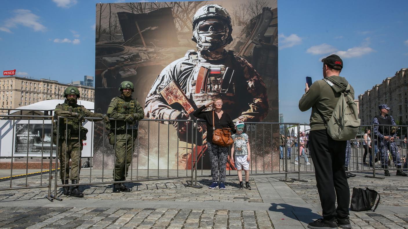 Dietro il poster con il soldato russo sono esposti 30 macchinari militari costruiti in Ue, USA e Sud Africa, sequestrati in Ucraina. Collina Poklonnaya, Mosca (27 maggio 2024.) 
