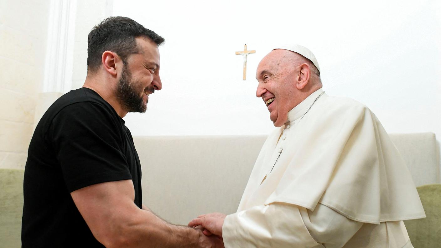 Papa Francesco e il presidente ucraino Zelensky si stringo la mano durante il vertice del G7