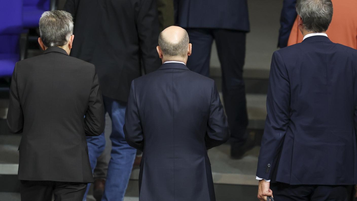 Olaf Scholz, al centro, lascia il Bundestag dopo il voto di fiducia fallito