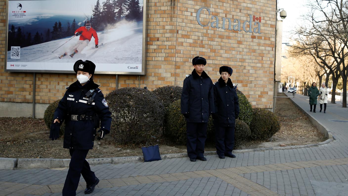 Agenti cinesi all'esterno dell'ambasciata canadese di Pechino