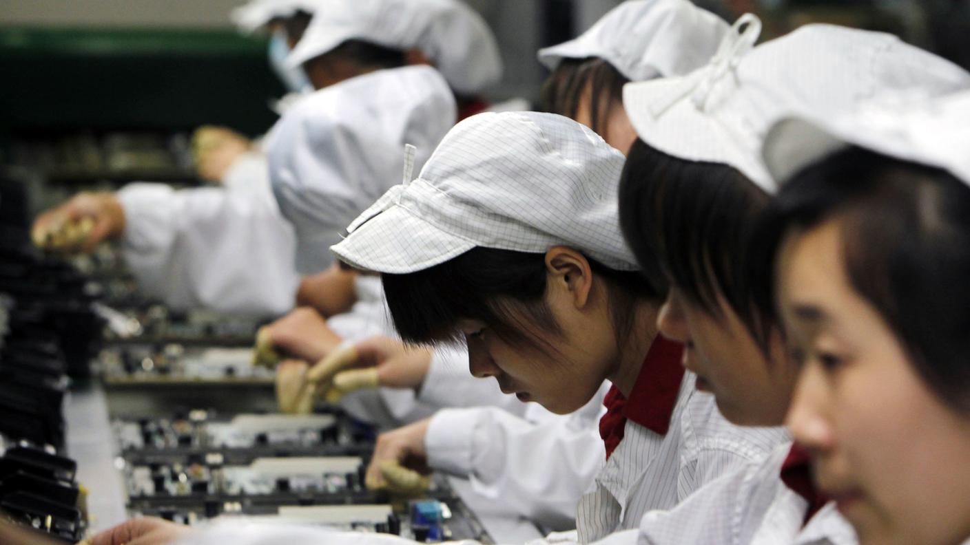 Operaie al lavoro in una fabbrica cinese di Foxconn, dove vengono assemblati iPhone